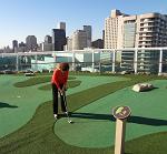 Playing mini-golf on the cruise ship with New Orleans in the background